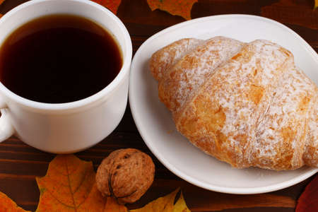 Cup of coffee and croissant autumn still lifeの写真素材