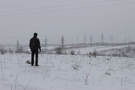 Lonely man standing in the snowの写真素材