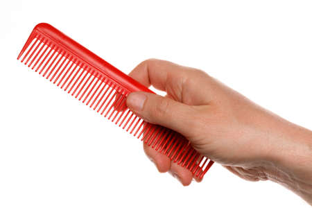 Red comb hair brush in hands on a white backgroundの写真素材