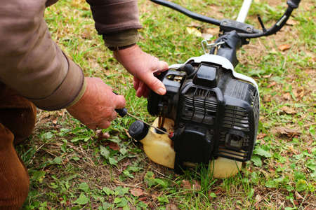 A man runs the motor of gasoline trimmerの写真素材