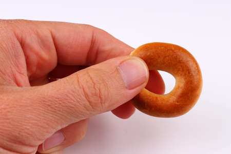 Bagel in hand on a white backgroundの写真素材