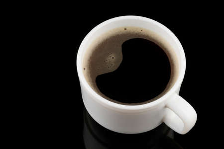 Coffee drink in a white cup on a black backgroundの写真素材