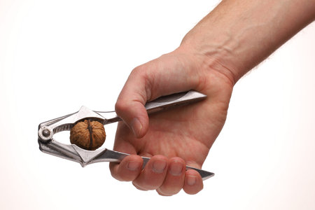 The nutcracker in a hand splits a walnutの写真素材