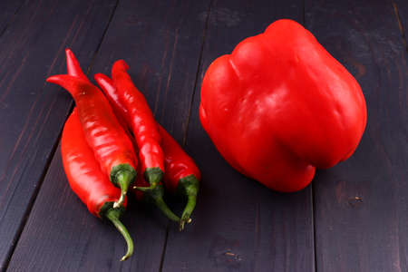 Red hot chili peppers and sweet on a wooden backgroundの写真素材