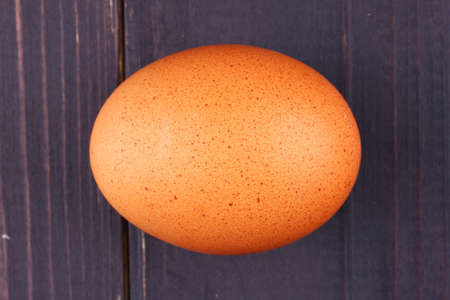 Brown chicken egg on a wooden backgroundの写真素材
