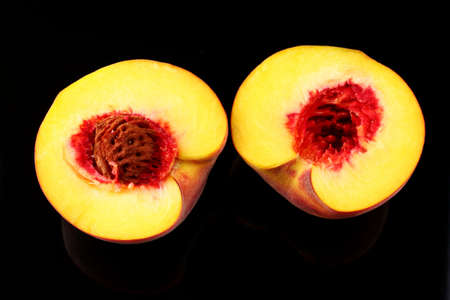 Whole and sliced peach on a dark backgroundの写真素材