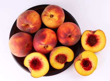 Peach on a white background in the plateの写真素材