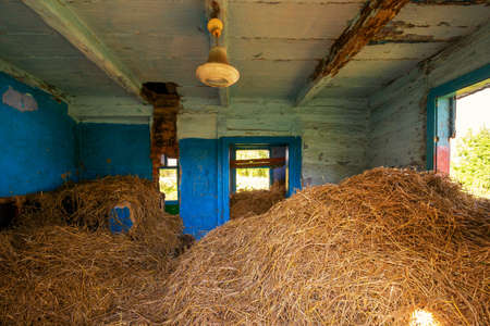 The old farmhouse is littered with hayの写真素材