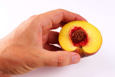 Peach on a white background in his handの写真素材