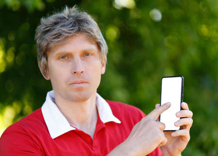A man points to a smartphone screen.の写真素材