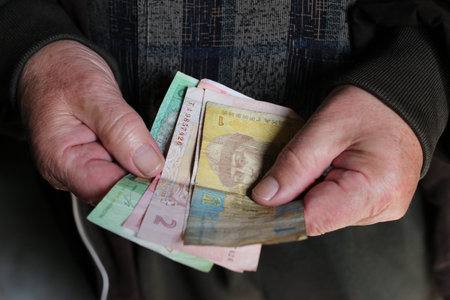 Ukrainian pensioner holds hryvnia moneyの写真素材