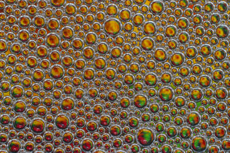 Colored drops of oil on the water. Background or texture.の写真素材