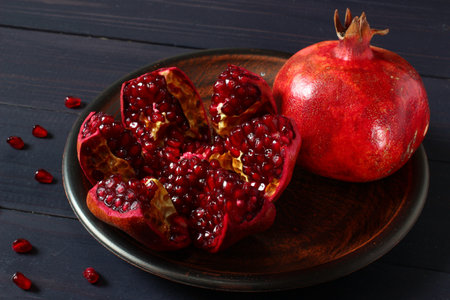 Two pomegranates on old rustic table still-life in dark tonesの写真素材