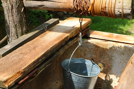 Old well with bucket close-up.の写真素材