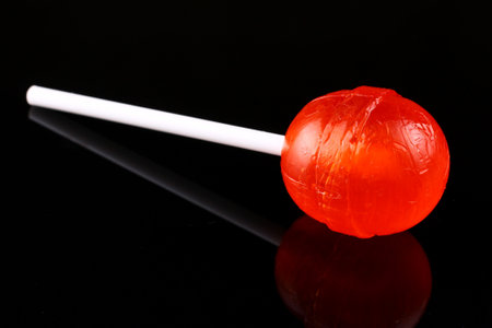 red candy on a stick on black backgroundの写真素材