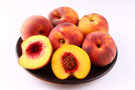 Peach in a plate on a dark white backgroundの写真素材