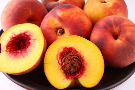 Peach in a plate on a dark white background close upの写真素材