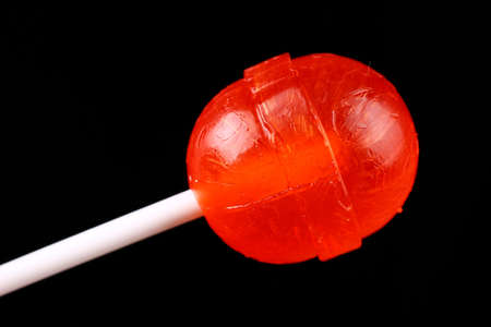 red candy on a stick on black backgroundの写真素材