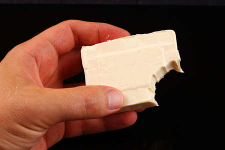Cream of cottage cheese bitten on black backgroundの写真素材