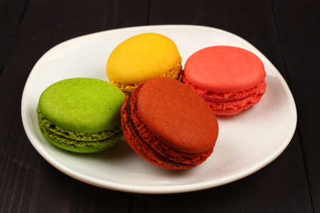 Several macaron sweets cookies in plate on black backgroundの写真素材