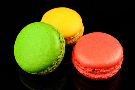 Macaroni colored pastry cookies on black backgroundの写真素材