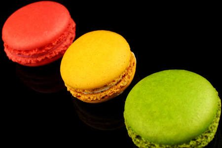 Macaroni colored pastry cookies on black backgroundの写真素材