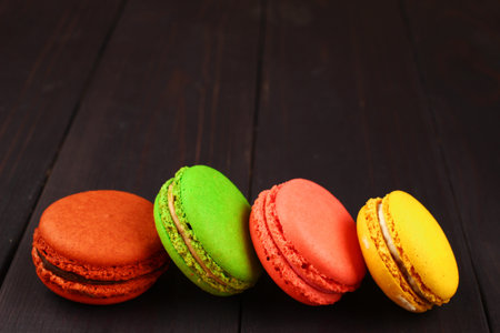 Macaroni colored pastry cookies on wooden background place for text cope spaceの写真素材