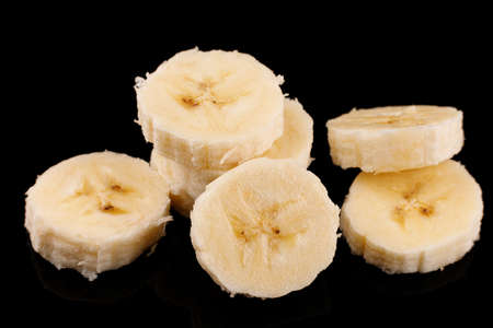 Slices of sliced banana on a black background.の写真素材