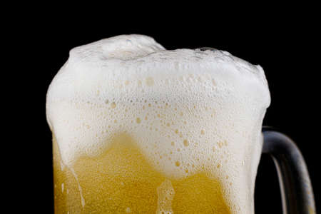 Glass of yellow unfiltered wheat beer and foamの写真素材