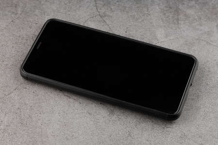The smartphone is turned off with a black screen on the tableの写真素材