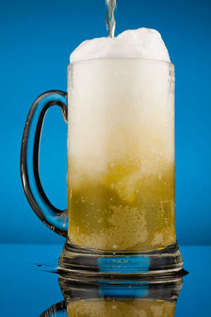 Beer in a glass and white foamの写真素材