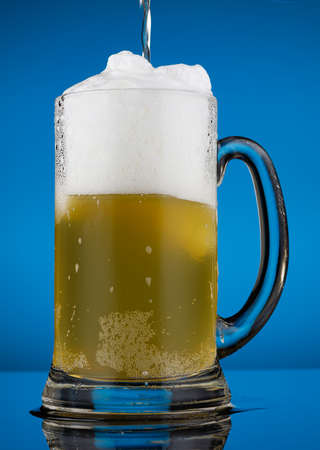 Beer in a glass and white foamの写真素材