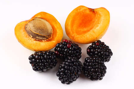A few blackberries and apricots on a white backgroundの写真素材