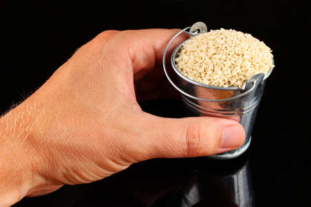 Sesame in a bucket on a black background