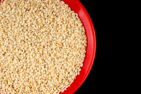 Sesame in a plate on a black backgroundの写真素材