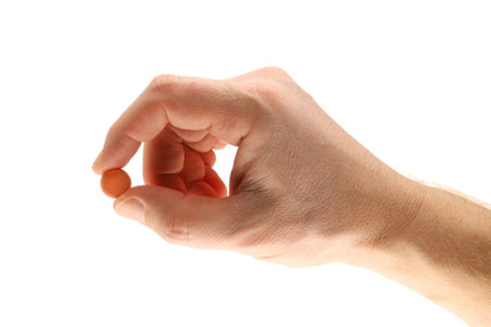 Hand holding vitamin C tablet isolateの写真素材