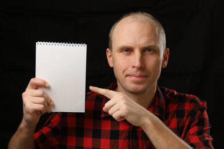 Caucasian man holding a blank notebookの写真素材