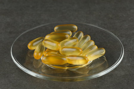 Omega 3 gelatin capsules close-up on a glass plateの写真素材