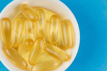 Omega 3 gelatin capsules in a white containerの写真素材