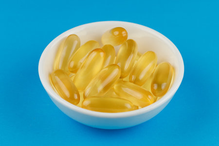 Omega 3 gelatin capsules in a white containerの写真素材