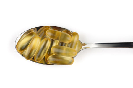 Omega 3 gelatin capsules in a spoon on a white backgroundの写真素材