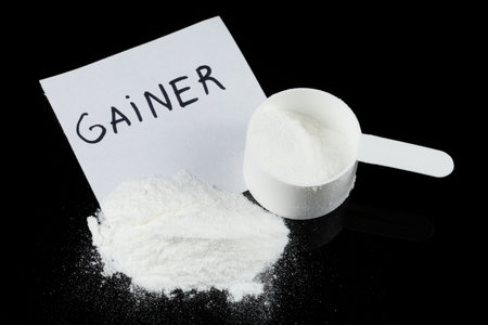 Gainer in a spoon. Sports nutrition and a measuring spoonの写真素材