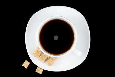 Coffee in a cup with a piece of brown sugar. Coffee on a black background top viewの写真素材