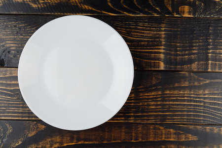 Empty white plate on wooden background place for text cope spaceの写真素材