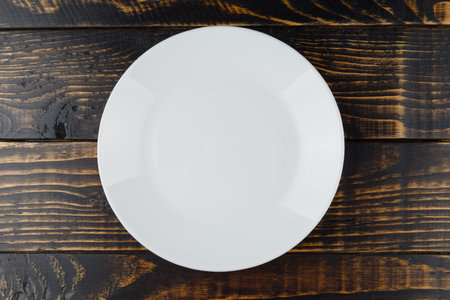 Empty white plate on wooden backgroundの写真素材