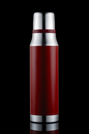 Red flask for drinks on black isolateの写真素材