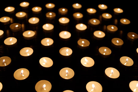 many small candles in the dark. candles background. Candles are a symbol of memory of the dead.の写真素材