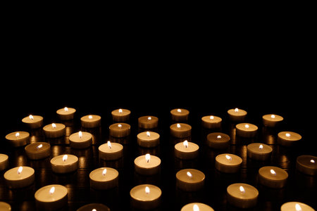 many small candles in the dark. candles background. Candles are a symbol of memory of the dead.の写真素材