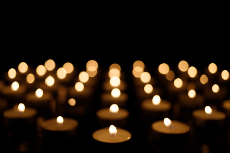 many small candles in the dark. candles background. Candles are a symbol of memory of the dead.の写真素材