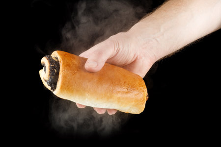 Hot poppy seed bun in handの写真素材